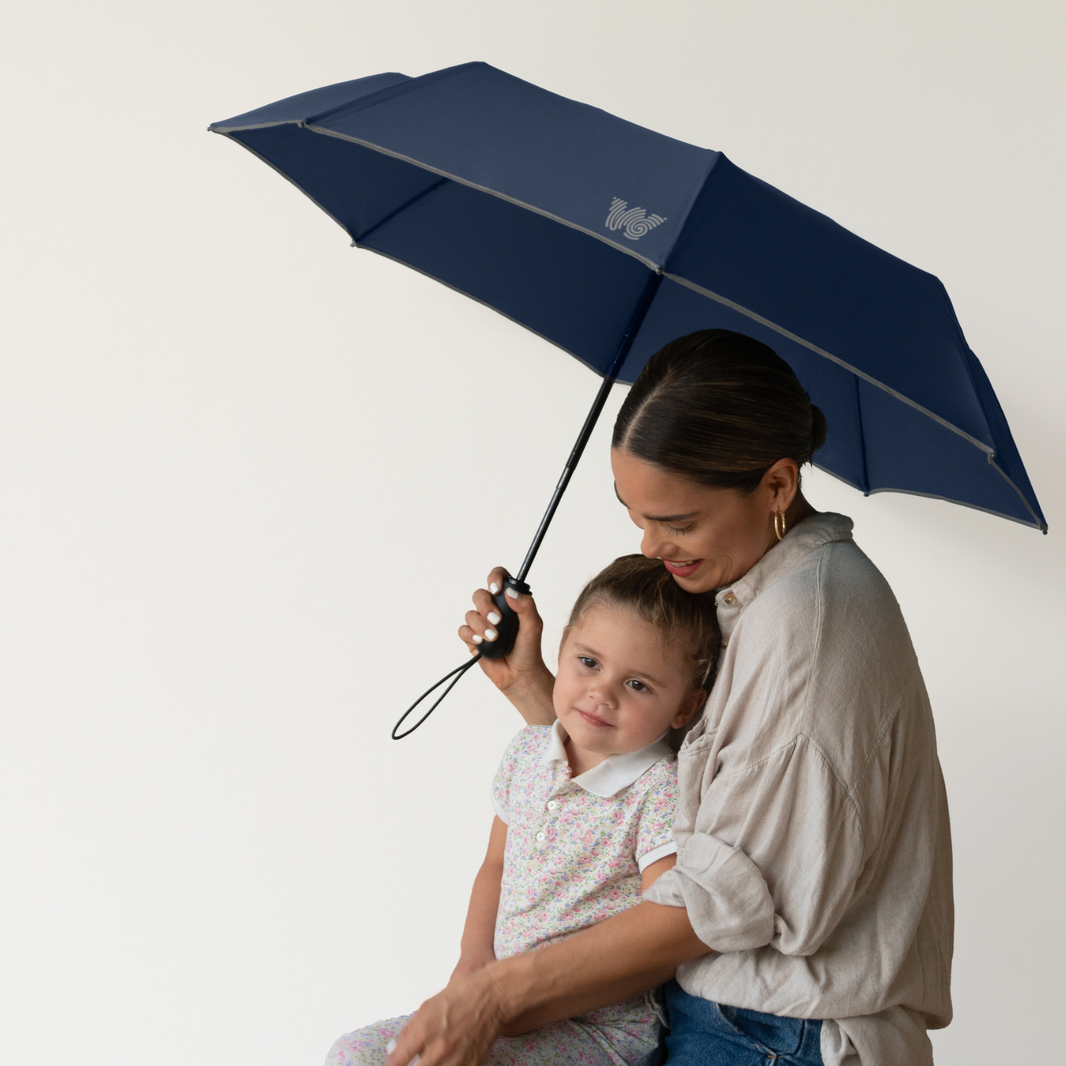 Woman holding her child with Weatherman Travel Umbrella in navy.